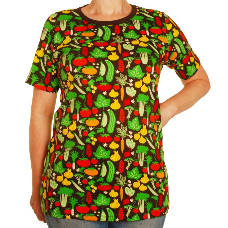 Woman with green hair and two children wearing matching vegetable-patterned clothing outdoors.