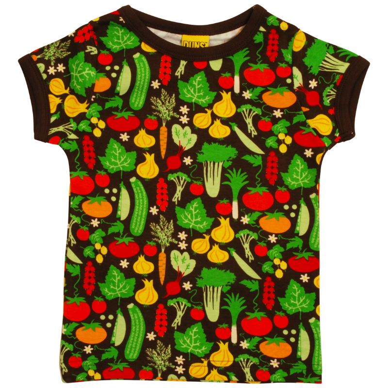 Child wearing a colorful DUNS Sweden t-shirt with vegetable patterns on a bus.