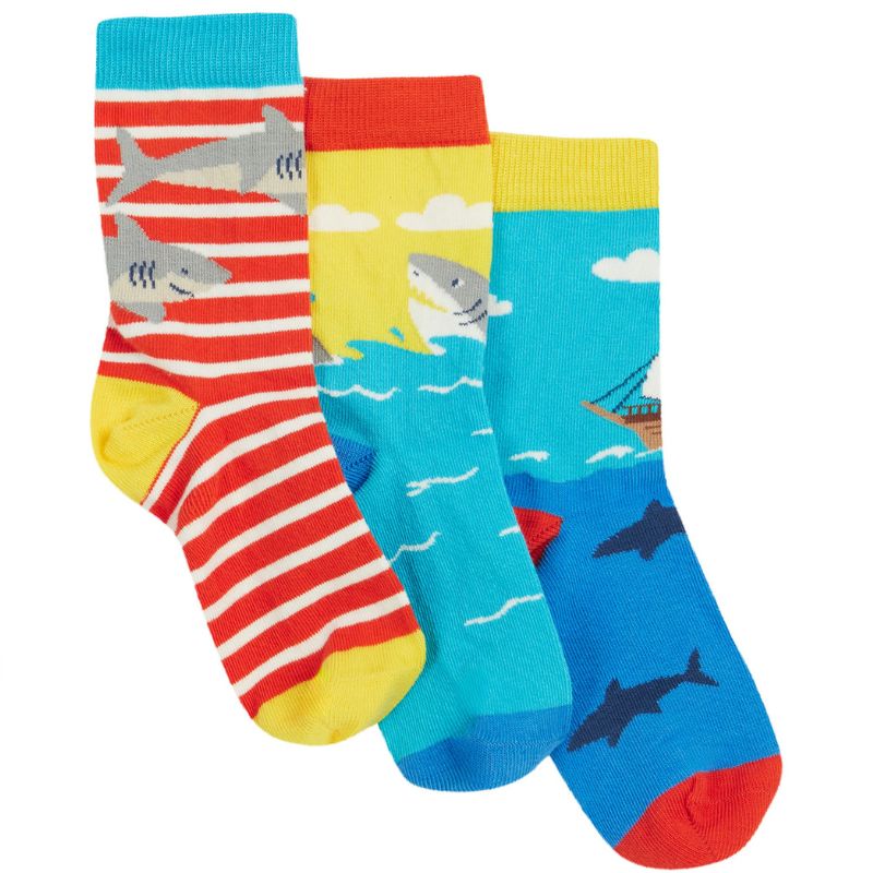 Three colorful children's socks with pirate and shark designs on a white background