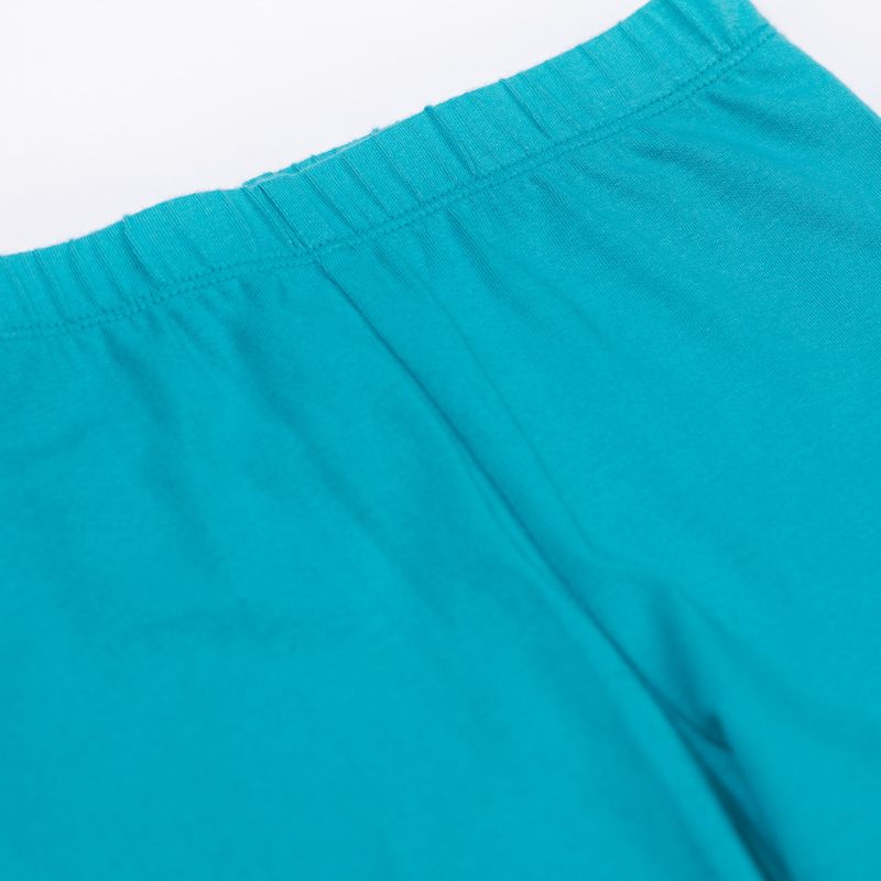 Close-up of turquoise leggings on a white background