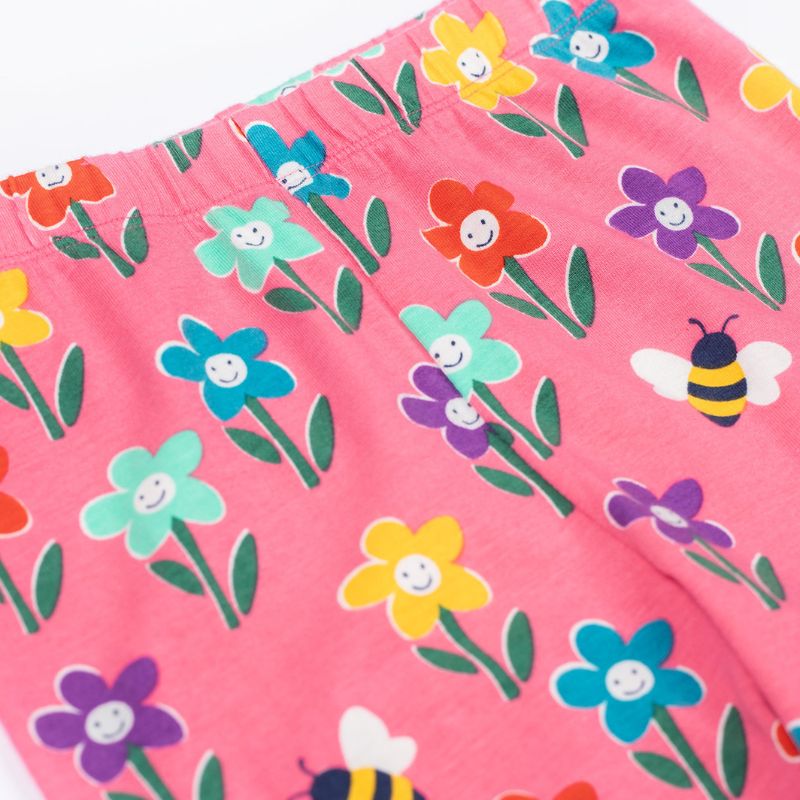 Close-up of a pink fabric with colorful flower and bee pattern