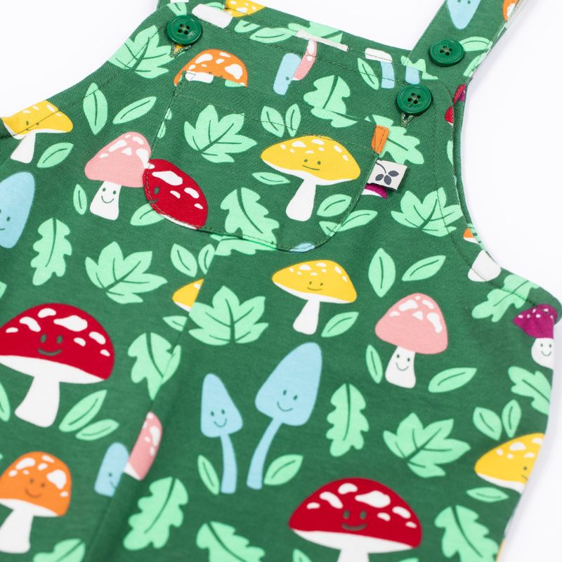 Green children's overalls with mushroom pattern on a white background