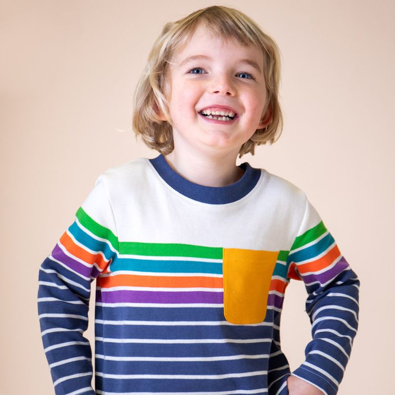 Child wearing a colorful striped shirt with a plain background