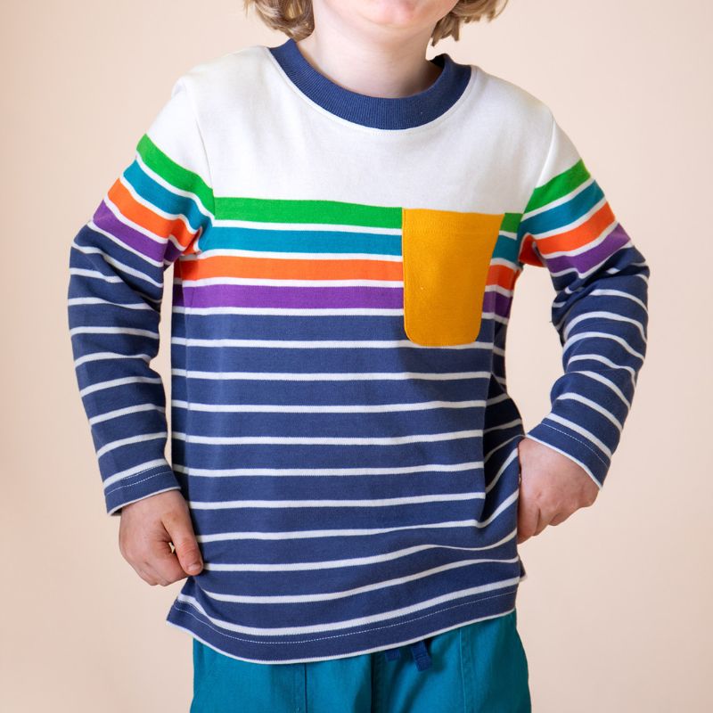 Child wearing a colorful striped shirt with a plain background