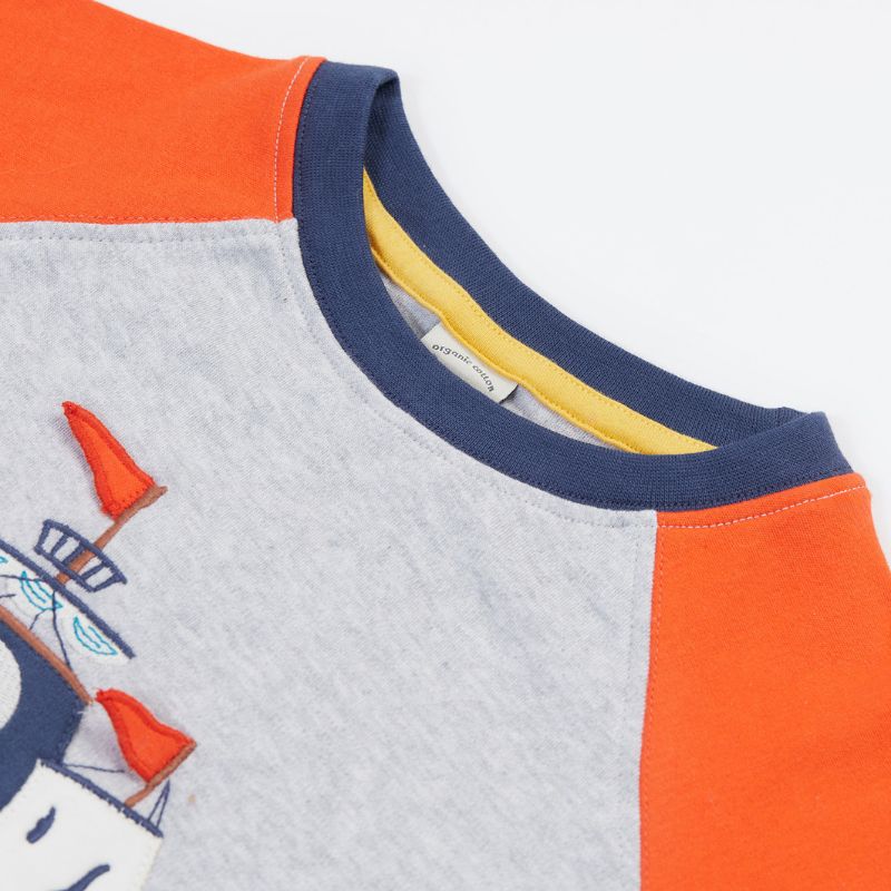 Close-up of a children&#39;s shirt with color-blocked design and applique  on a white background