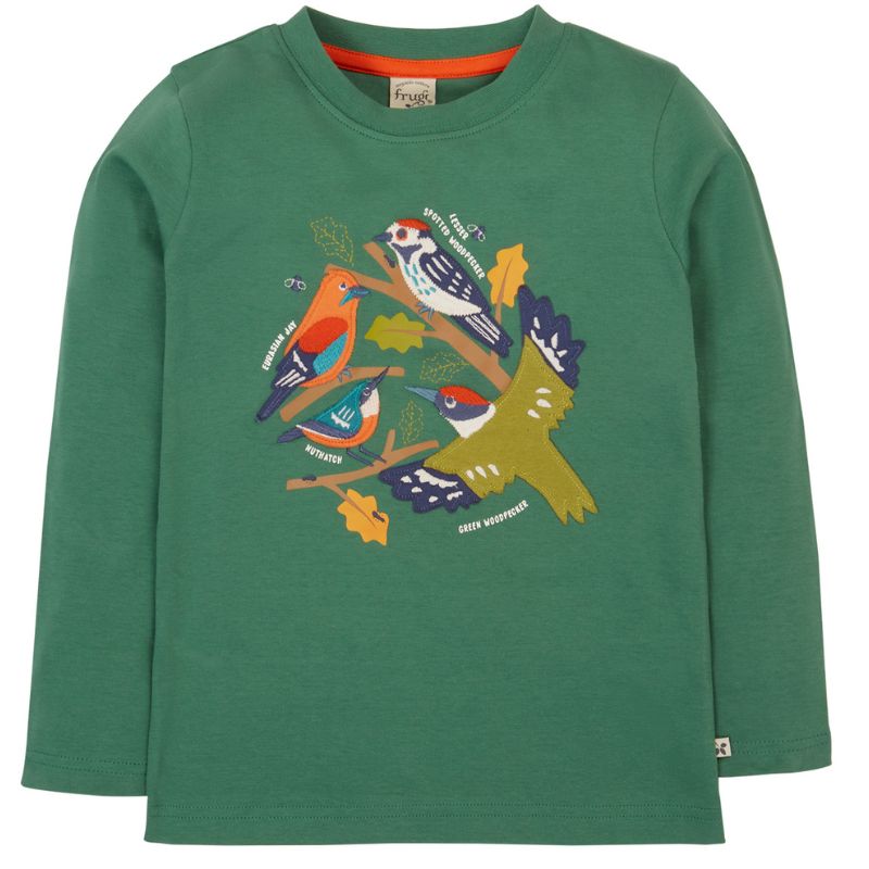 Child wearing a green long-sleeve shirt with colorful bird design outdoors