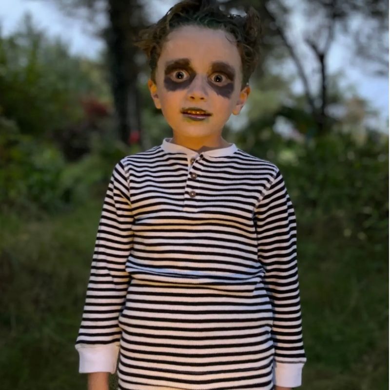 Child wearing a striped shirt with a blurred natural background